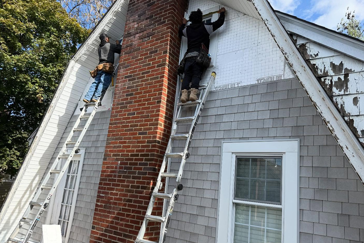 Exterior siding options include textured grey cedar-style shingles, white horizontal lap siding, and protective orange or green ZIP System sheathing used during active construction in Long Island.