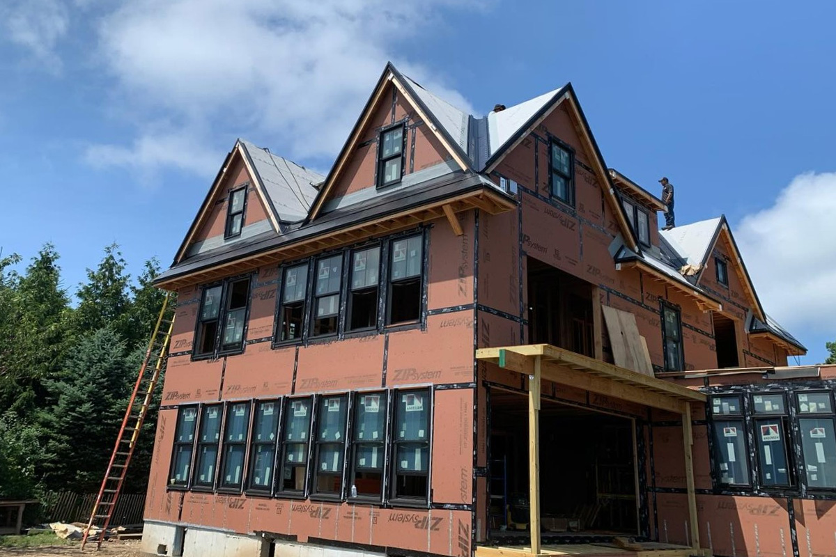 Residential exterior showcase diverse siding options, including grey cedar-style shingles, classic white horizontal planks, and orange ZIP System protective sheathing during construction.
