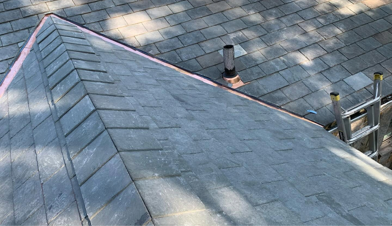 Detailed view of metal flashing around a white chimney, a common area addressed when attempting to fix a roof leak.