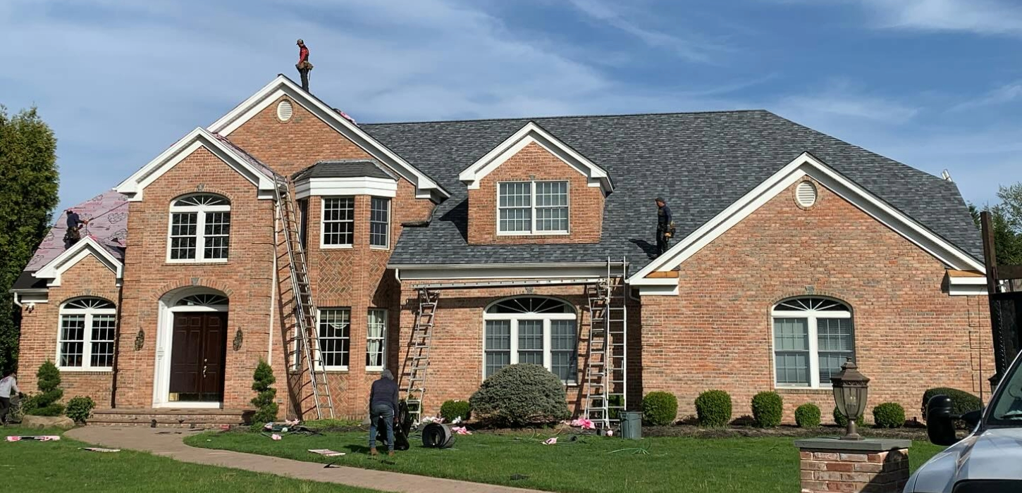 A professional contractor meticulously inspects a residential shingle roof to determine the best way to fix a roof leak.