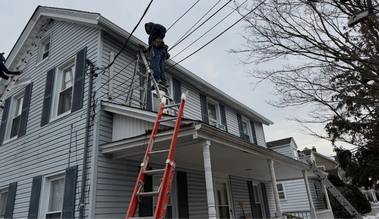 A professional contractor safely walking on a steep residential roof to perform a detailed inspection for routine roof maintenance.