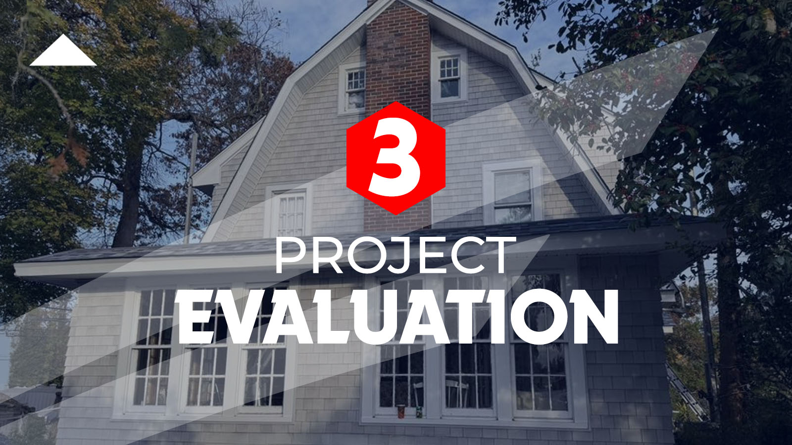 Project fro steps, displays multi-tonal grey and blue shingle roofing of a two-story home. The house features light-colored siding, multiple windows, and a prominent brick chimney.