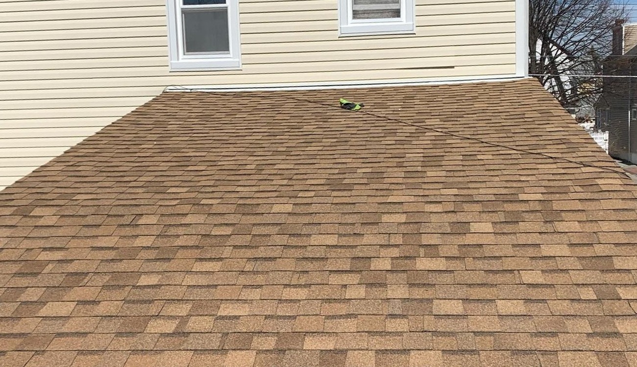 Looking down a bright brown roof slope provides valuable insight into the asphalt shingles vs architectural shingles overall aesthetic differences.